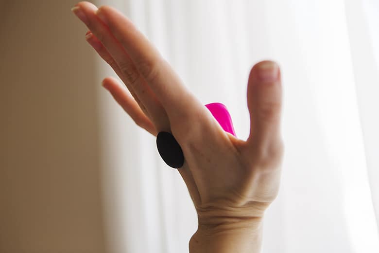 Lovense Ferri magnet attached to the toy through my hand demonstrating the magnet's strength